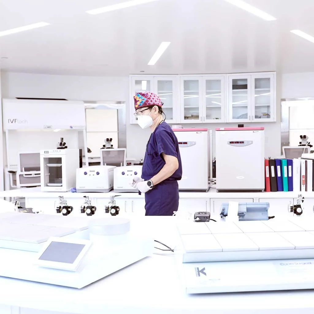 An IRFC embryologist working at the microscope in the IVF laboratory during preimplantation genetic testing.